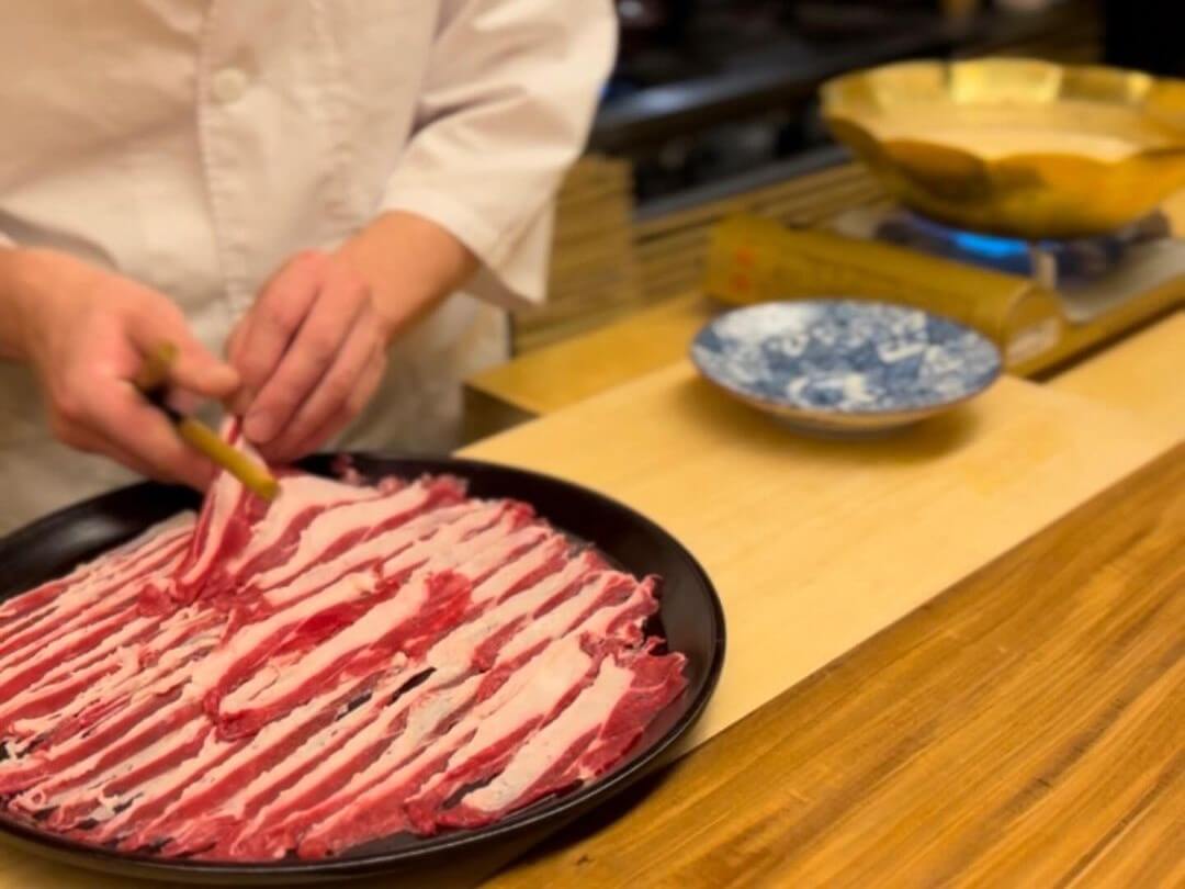 A Kappo chef prepares meat at the counter for cooking