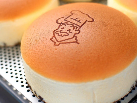 A fluffy Japanese jiggly cheesecake sits on a cooling tray