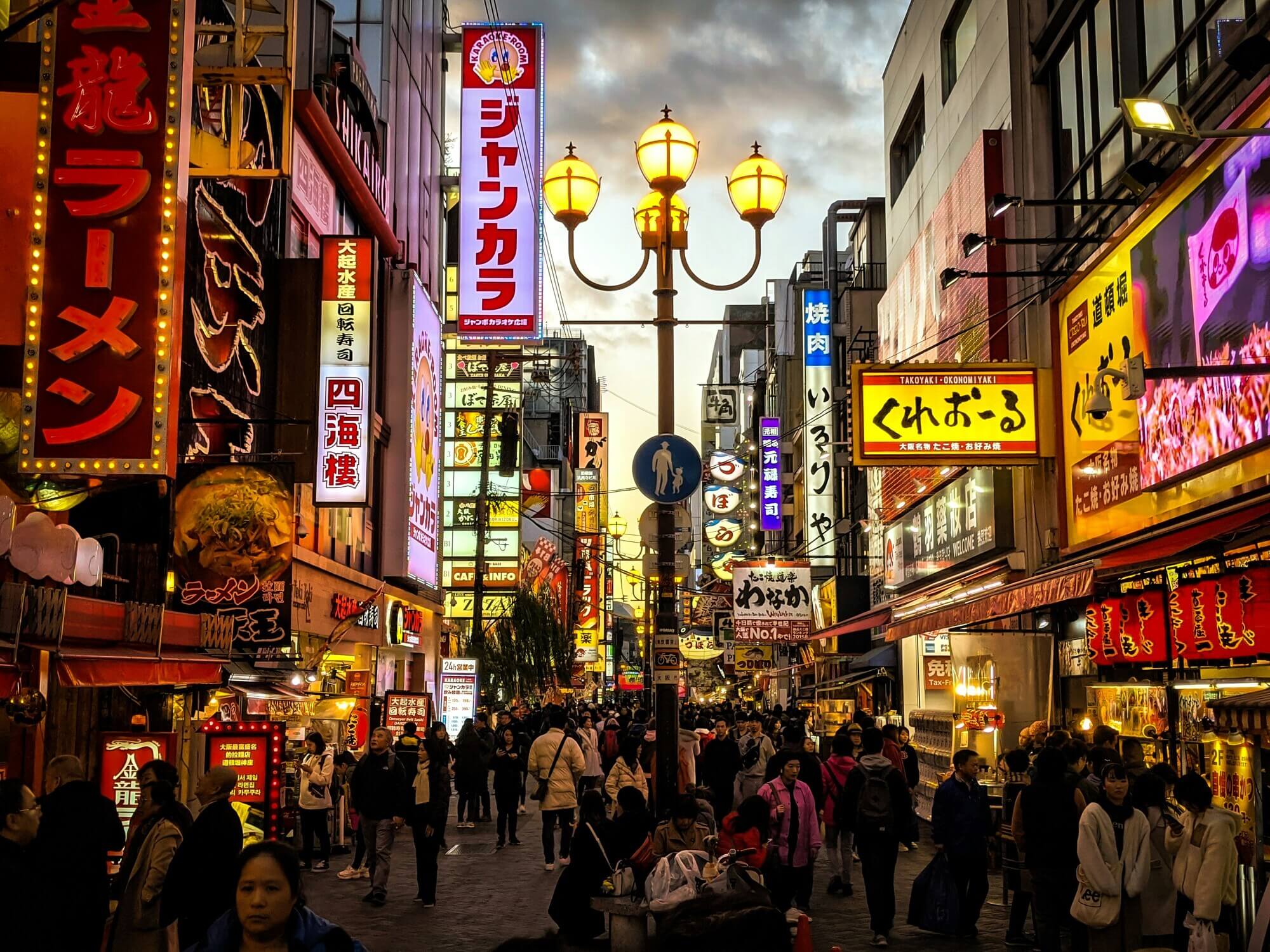 A view of the busy food shop area with many bright signs in the Dotonbori area