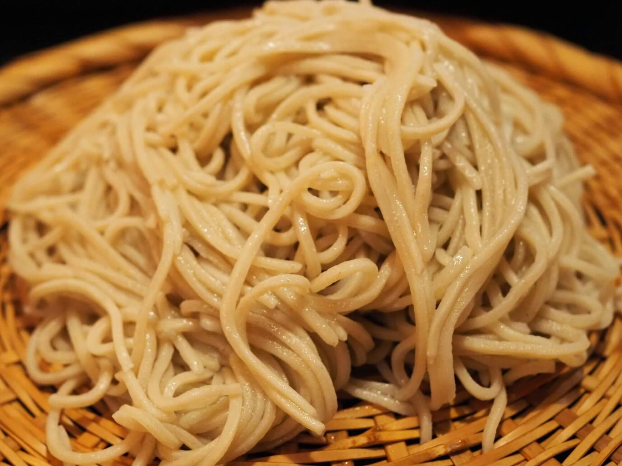 A small mountain of soba sits on a Japanese zaru tray