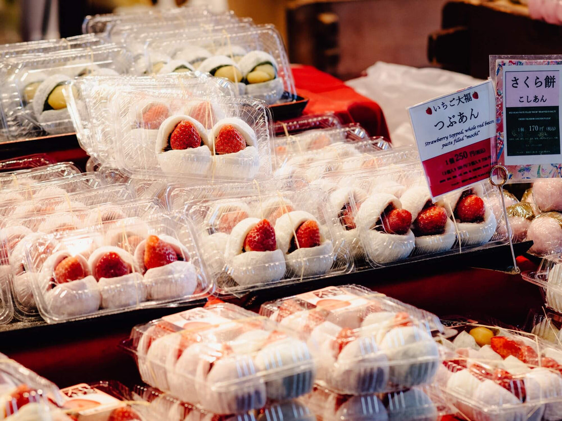 A display of many strawberry mochi treats on a sales table
