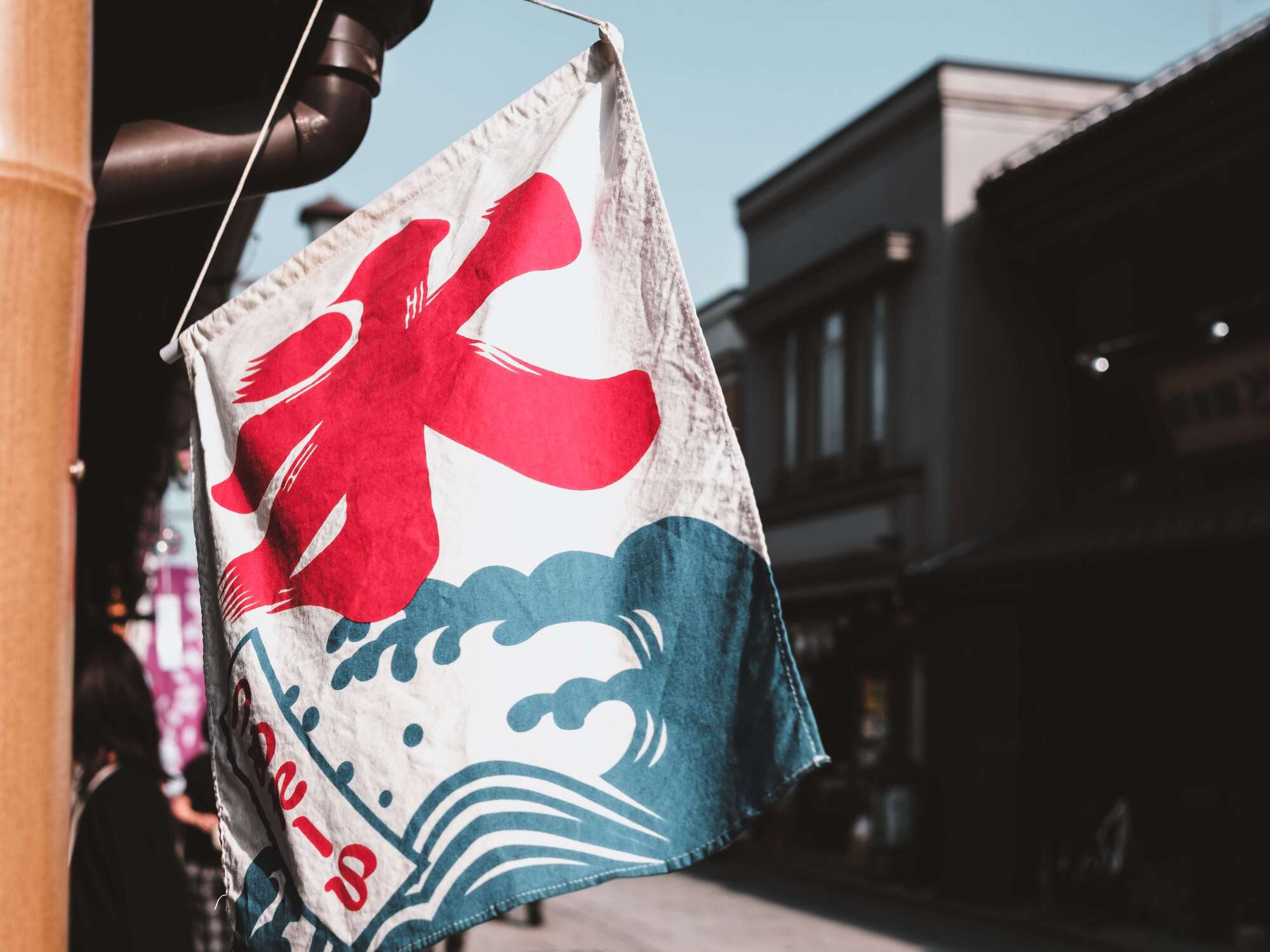 A kakigori shop sign flows in the wind in front of the shop